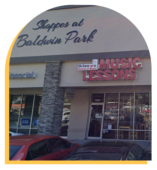 A storefront with a sign reading Orlando School of Music MUSIC LESSONS in the Shoppes at Baldwin Park shopping center. Several cars are parked in front of this music school, offering lessons like those at Step Up music lessons.
